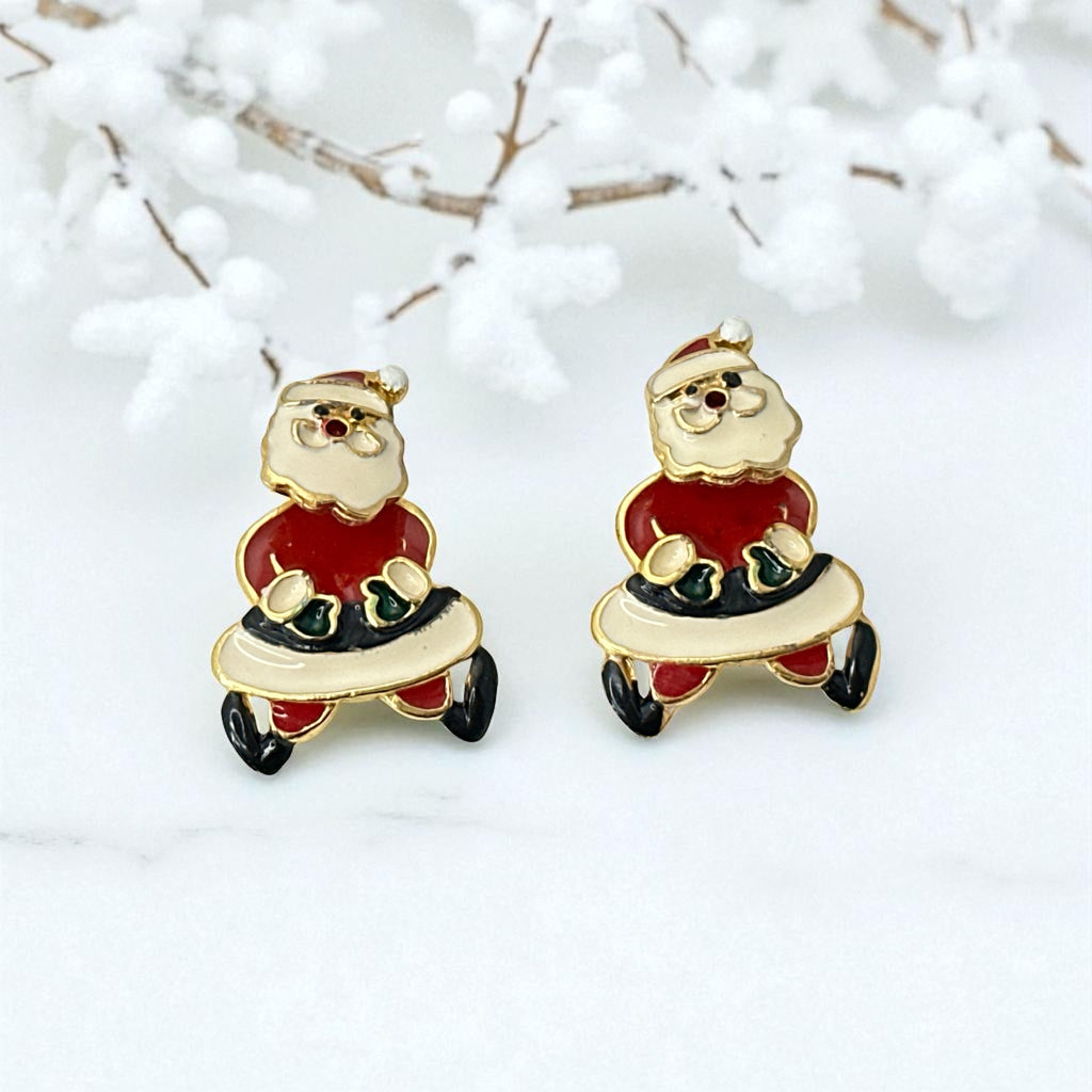 Vintage AIM Santa earrings with red, white, and black enamel, signed with copyright mark, featuring movable head and pierced stud design.