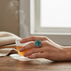 Adjustable silver-tone cocktail ring with a large round aqua rhinestone cabochon and open swirl design set with smaller teal rhinestones; vintage-inspired statement jewelry in very good condition.