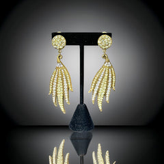 Vintage gold-tone clip-on earrings with jonquil and clear rhinestones in a feather-like Art Deco revival design; long dangle silhouette, 1970s style.