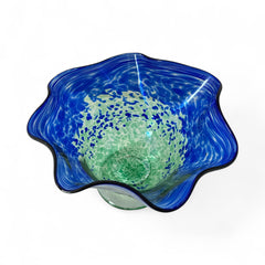 Signed BAGI art glass bowl with a footed base and wavy rim, featuring mottled blue and green swirls. The glass has a glossy finish and sculptural form, with vibrant oceanic and forest tones. Dimensions approximately 5–5½" tall and 7–8" wide.