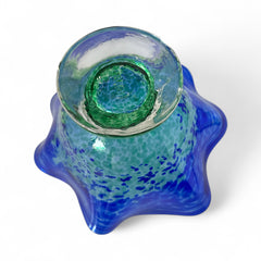 Signed BAGI art glass bowl with a footed base and wavy rim, featuring mottled blue and green swirls. The glass has a glossy finish and sculptural form, with vibrant oceanic and forest tones. Dimensions approximately 5–5½" tall and 7–8" wide.