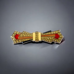 Vintage Art Deco style bow brooch with geometric enamel and resin design in black, gold, red, and white on silver tone base.