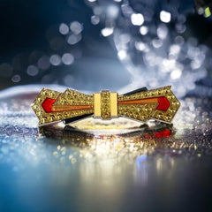 Vintage Art Deco style bow brooch with geometric enamel and resin design in black, gold, red, and white on silver tone base.