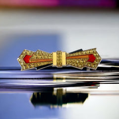 Vintage Art Deco style bow brooch with geometric enamel and resin design in black, gold, red, and white on silver tone base.