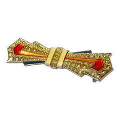 Vintage Art Deco style bow brooch with geometric enamel and resin design in black, gold, red, and white on silver tone base.