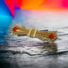 Vintage Art Deco style bow brooch with geometric enamel and resin design in black, gold, red, and white on silver tone base.