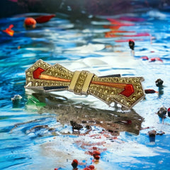 Vintage Art Deco style bow brooch with geometric enamel and resin design in black, gold, red, and white on silver tone base.