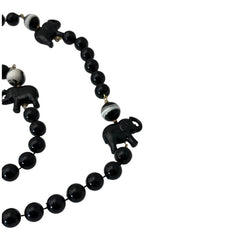 Vintage 1990s necklace featuring a symmetrical design with two elephant-shaped black beads, two black-and-white beads resembling banded agate, and a strand of 8mm black plastic beads in very good condition