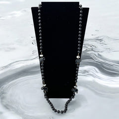 Vintage 1990s necklace featuring a symmetrical design with two elephant-shaped black beads, two black-and-white beads resembling banded agate, and a strand of 8mm black plastic beads in very good condition