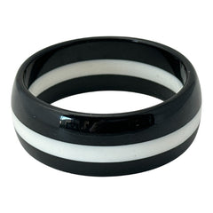 vintage black and white striped Lucite bangle bracelet with a sleek modern design inspired by 70s or 80s fashion. Featuring a white central ring framed by black rings on each side, this unsigned bracelet is in very good condition and makes a bold statement accessory.