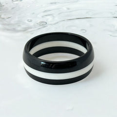 vintage black and white striped Lucite bangle bracelet with a sleek modern design inspired by 70s or 80s fashion. Featuring a white central ring framed by black rings on each side, this unsigned bracelet is in very good condition and makes a bold statement accessory.