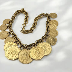 Vintage Franklin Mint Caribbean Coins necklace from the 1980s, featuring 14 uncirculated 24k gold-plated coins from Caribbean Islands on a textured chain.