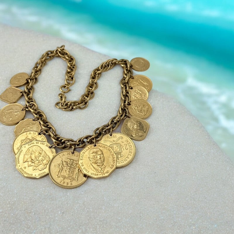 Vintage Franklin Mint Caribbean Coins necklace from the 1980s, featuring 14 uncirculated 24k gold-plated coins from Caribbean Islands on a textured chain.