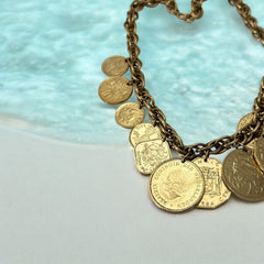 Vintage Franklin Mint Caribbean Coins necklace from the 1980s, featuring 14 uncirculated 24k gold-plated coins from Caribbean Islands on a textured chain.