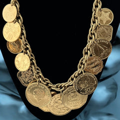 Vintage Franklin Mint Caribbean Coins necklace from the 1980s, featuring 14 uncirculated 24k gold-plated coins from Caribbean Islands on a textured chain.
