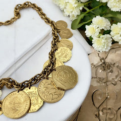 Vintage Franklin Mint Caribbean Coins necklace from the 1980s, featuring 14 uncirculated 24k gold-plated coins from Caribbean Islands on a textured chain.
