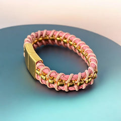 Elegant Daniel Steiger Melrose bracelet featuring braided pink leather on each side of yellow gold-plated center links, finished with a gold-plated magnetic slide clasp, photographed against a neutral backdrop.