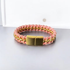 Elegant Daniel Steiger Melrose bracelet featuring braided pink leather on each side of yellow gold-plated center links, finished with a gold-plated magnetic slide clasp, photographed against a neutral backdrop.