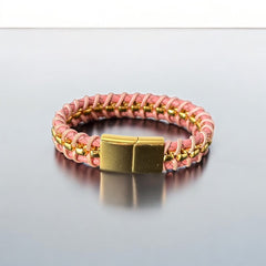 Elegant Daniel Steiger Melrose bracelet featuring braided pink leather on each side of yellow gold-plated center links, finished with a gold-plated magnetic slide clasp, photographed against a neutral backdrop.