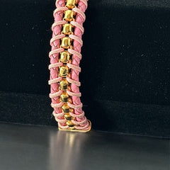 Elegant Daniel Steiger Melrose bracelet featuring braided pink leather on each side of yellow gold-plated center links, finished with a gold-plated magnetic slide clasp, photographed against a neutral backdrop.