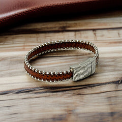Erica Zap signed brown leather bracelet with silver-tone beaded edges and a textured magnetic clasp, modern artisan design in very good condition.
