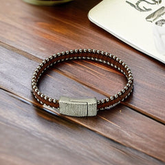 Erica Zap signed brown leather bracelet with silver-tone beaded edges and a textured magnetic clasp, modern artisan design in very good condition.