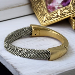 Signed Erica Zap bracelet featuring a rhodium-plated woven mesh band and a matte 18K gold electroplated crescent clasp. Sculptural magnetic closure with mixed-metal contrast. Shown from multiple angles to highlight clasp detail, mesh texture, and overall condition.