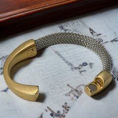 Signed Erica Zap bracelet featuring a rhodium-plated woven mesh band and a matte 18K gold electroplated crescent clasp. Sculptural magnetic closure with mixed-metal contrast. Shown from multiple angles to highlight clasp detail, mesh texture, and overall condition.