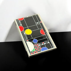 Acme Studio business/credit card case featuring Frank Lloyd Wright's 'Playhouse' design, showcasing geometric patterns with red, yellow, and blue accents on a black background, crafted with mirror chrome metal finish and lacquer-filled acid-etched image.