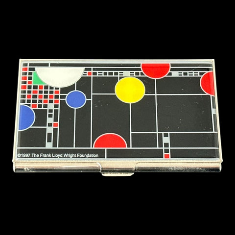 Acme Studio business/credit card case featuring Frank Lloyd Wright's 'Playhouse' design, showcasing geometric patterns with red, yellow, and blue accents on a black background, crafted with mirror chrome metal finish and lacquer-filled acid-etched image.