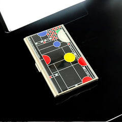 Acme Studio business/credit card case featuring Frank Lloyd Wright's 'Playhouse' design, showcasing geometric patterns with red, yellow, and blue accents on a black background, crafted with mirror chrome metal finish and lacquer-filled acid-etched image.