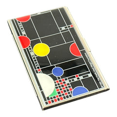Acme Studio business/credit card case featuring Frank Lloyd Wright's 'Playhouse' design, showcasing geometric patterns with red, yellow, and blue accents on a black background, crafted with mirror chrome metal finish and lacquer-filled acid-etched image.