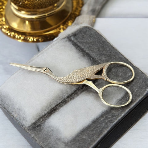 Antique French stork-shaped embroidery scissors from the late 1800s to early 1900s. Crafted with intricate details, the silver-tone finish shows charming wear, revealing darker metal and hints of faded gold-tone accents on the stork’s body when opened. A collectible and decorative piece embodying timeless craftsmanship and vintage elegance.