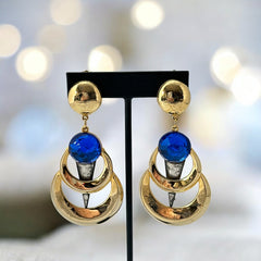 Vintage French modernist clip-on earrings with faceted blue round cabochons, layered gold and silver-tone metal crescents, and long sculptural dangles; shown from multiple angles to highlight texture, asymmetry, and mixed-metal design.