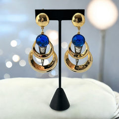 Vintage French modernist clip-on earrings with faceted blue round cabochons, layered gold and silver-tone metal crescents, and long sculptural dangles; shown from multiple angles to highlight texture, asymmetry, and mixed-metal design.
