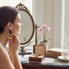 Vintage French modernist clip-on earrings with faceted blue round cabochons, layered gold and silver-tone metal crescents, and long sculptural dangles; shown from multiple angles to highlight texture, asymmetry, and mixed-metal design.