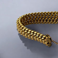 Vintage French gold-plated curb mesh bracelet from the 1960s/70s, featuring three soldered curb chains with a textured mesh design, a safety catch clasp with a safety chain, and intriguing marks (5M and an unclear jeweler's signature). Measures 8 inches long and showcases light vintage wear.