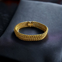 Vintage French gold-plated curb mesh bracelet from the 1960s/70s, featuring three soldered curb chains with a textured mesh design, a safety catch clasp with a safety chain, and intriguing marks (5M and an unclear jeweler's signature). Measures 8 inches long and showcases light vintage wear.