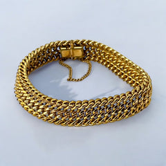 Vintage French gold-plated curb mesh bracelet from the 1960s/70s, featuring three soldered curb chains with a textured mesh design, a safety catch clasp with a safety chain, and intriguing marks (5M and an unclear jeweler's signature). Measures 8 inches long and showcases light vintage wear.