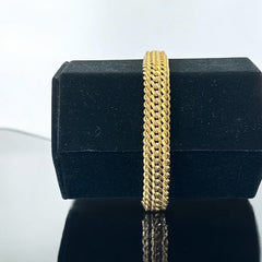Vintage French gold-plated curb mesh bracelet from the 1960s/70s, featuring three soldered curb chains with a textured mesh design, a safety catch clasp with a safety chain, and intriguing marks (5M and an unclear jeweler's signature). Measures 8 inches long and showcases light vintage wear.