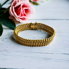 Vintage French gold-plated curb mesh bracelet from the 1960s/70s, featuring three soldered curb chains with a textured mesh design, a safety catch clasp with a safety chain, and intriguing marks (5M and an unclear jeweler's signature). Measures 8 inches long and showcases light vintage wear.