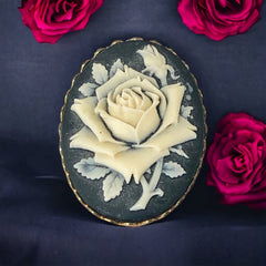 A lovely vintage French faux cameo scarf/dress clip from the late 1950s or early 1960s. Featuring a cream-colored high relief rose set against a black background, encased in a scalloped gold-tone bezel. The hammered gold frame adds texture, while the clip at the back ensures secure attachment to scarves, dresses, or lapels. Marked '3S' on the back, though the maker is unknown. A timeless and elegant accessory, perfect for vintage lovers and sustainable fashion enthusiasts.