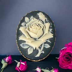 A lovely vintage French faux cameo scarf/dress clip from the late 1950s or early 1960s. Featuring a cream-colored high relief rose set against a black background, encased in a scalloped gold-tone bezel. The hammered gold frame adds texture, while the clip at the back ensures secure attachment to scarves, dresses, or lapels. Marked '3S' on the back, though the maker is unknown. A timeless and elegant accessory, perfect for vintage lovers and sustainable fashion enthusiasts.