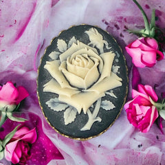 A lovely vintage French faux cameo scarf/dress clip from the late 1950s or early 1960s. Featuring a cream-colored high relief rose set against a black background, encased in a scalloped gold-tone bezel. The hammered gold frame adds texture, while the clip at the back ensures secure attachment to scarves, dresses, or lapels. Marked '3S' on the back, though the maker is unknown. A timeless and elegant accessory, perfect for vintage lovers and sustainable fashion enthusiasts.