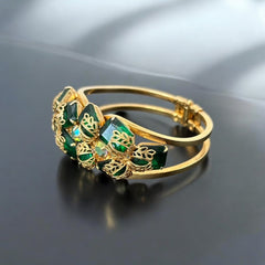 Vintage Juliana clamper bracelet from the 1950s, featuring 10 emerald-shaped rhinestones with filigree leaves, three AB light green rhinestones, and a gold-tone finish. A glamorous statement piece in excellent condition.