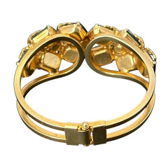 Vintage Juliana clamper bracelet from the 1950s, featuring 10 emerald-shaped rhinestones with filigree leaves, three AB light green rhinestones, and a gold-tone finish. A glamorous statement piece in excellent condition.