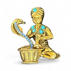 Vintage Hattie Carnegie snake charmer brooch with turquoise cabochons and blue rhinestones, gold tone metal, signed with copyright mark, 1960s figural costume jewelry.