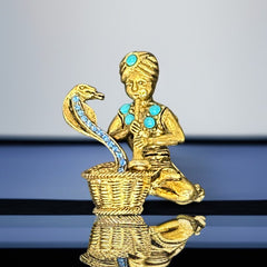 Vintage Hattie Carnegie snake charmer brooch with turquoise cabochons and blue rhinestones, gold tone metal, signed with copyright mark, 1960s figural costume jewelry.