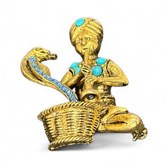 Vintage Hattie Carnegie snake charmer brooch with turquoise cabochons and blue rhinestones, gold tone metal, signed with copyright mark, 1960s figural costume jewelry.