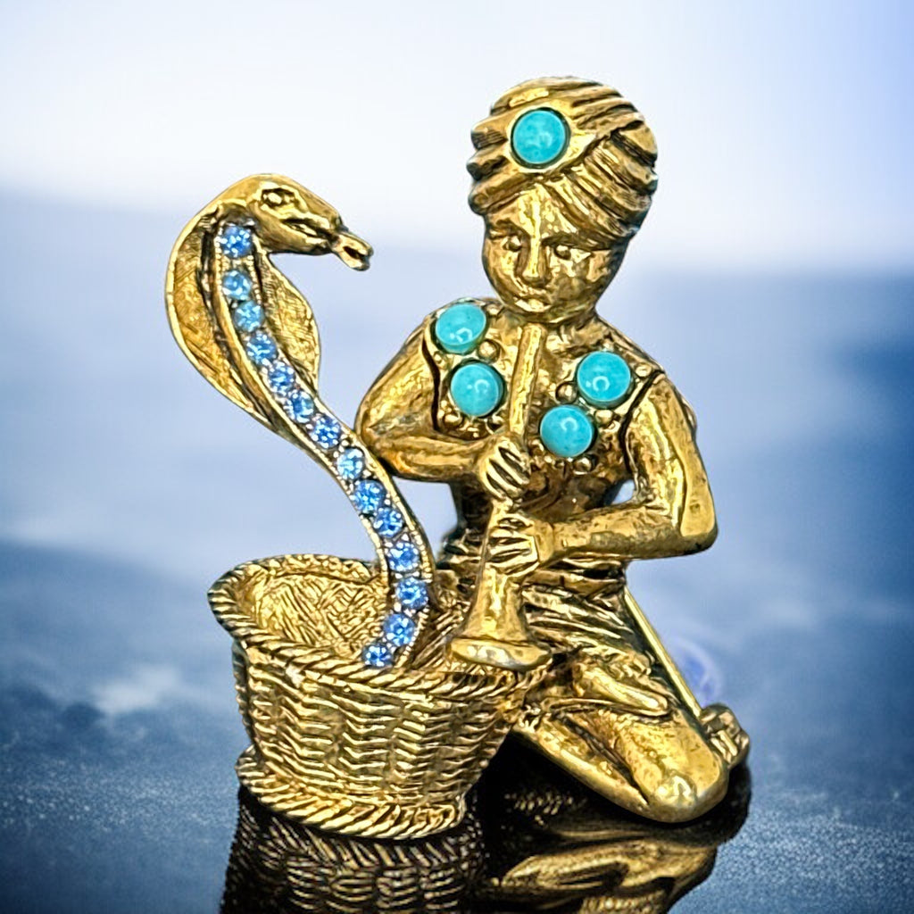 Vintage Hattie Carnegie snake charmer brooch with turquoise cabochons and blue rhinestones, gold tone metal, signed with copyright mark, 1960s figural costume jewelry.